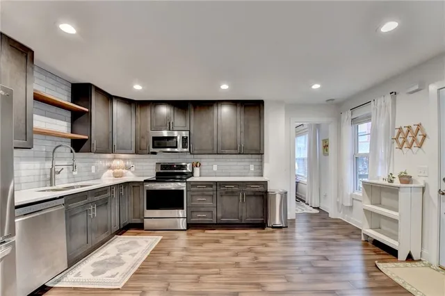 a large kitchen with stainless steel appliances granite countertop a sink and cabinets