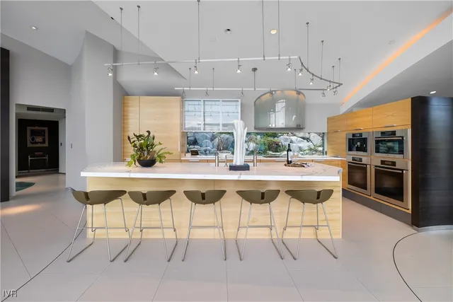 a dining table with chairs and kitchen view
