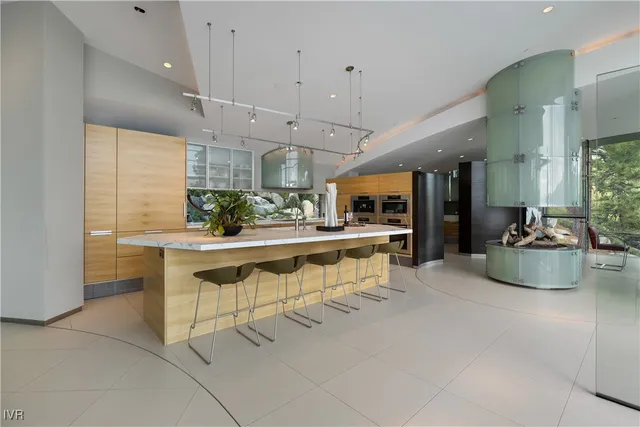a kitchen with stainless steel appliances kitchen island granite countertop a table and chairs in it