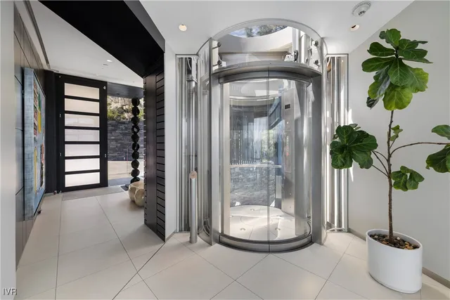 a glass vase with flowers sitting on a table and a chandelier