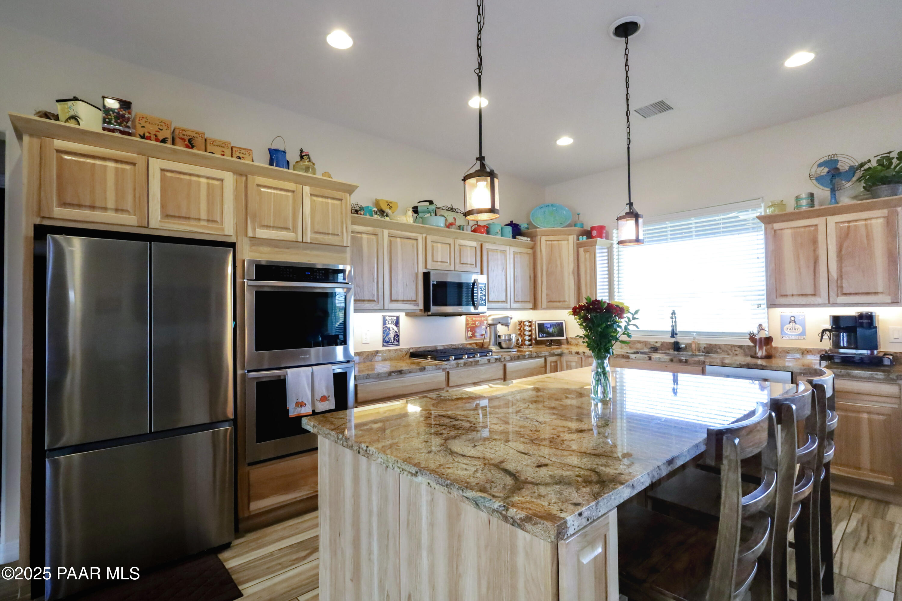 9860 North Loper Road Prescott Valley, AZ 86315 - Photo 13 of 53 a kitchen with stainless steel appliances granite countertop a table chairs and a refrigerator