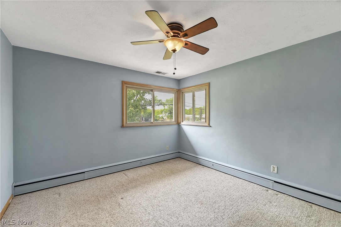 14593 Turney Road Maple Heights, OH 44137 - Photo 14 of 45 Bedroom with ceiling fan, baseboard heating, and carpet flooring