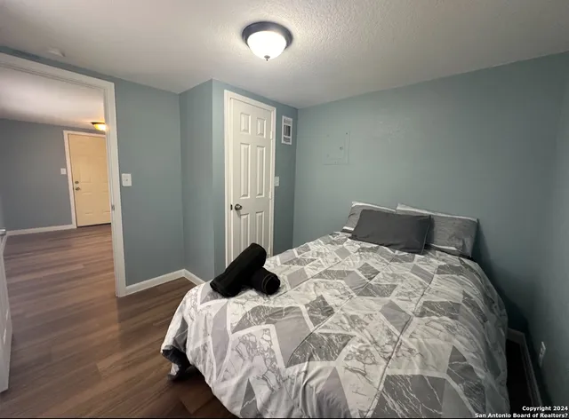 a bedroom with a bed and wooden floor