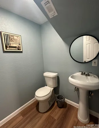 a bathroom with a toilet a sink and mirror