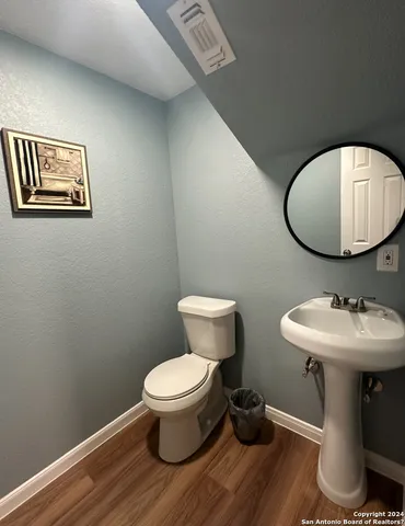 a bathroom with a toilet a sink and mirror