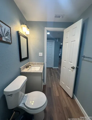 a bathroom with a toilet a sink and mirror