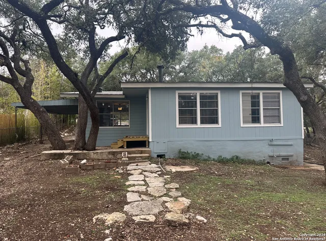 a backyard of a house with table and chairs
