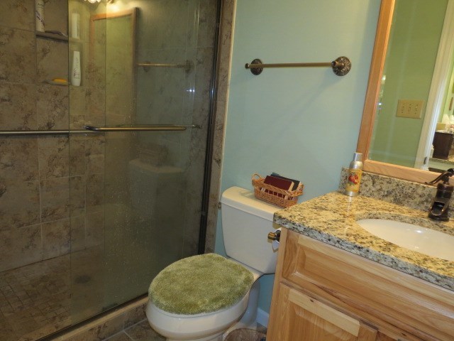 6974 Columbus Road Lizella, GA 31052 - Photo 12 of 19 a bathroom with a granite countertop sink toilet and shower