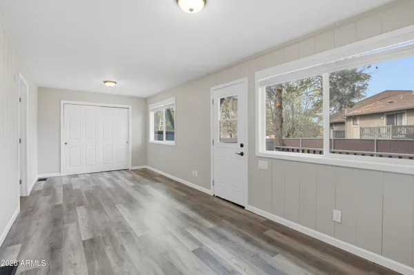 a view of empty room with wooden floor and fan