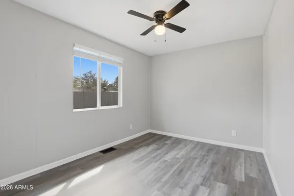 a view of empty room with wooden floor