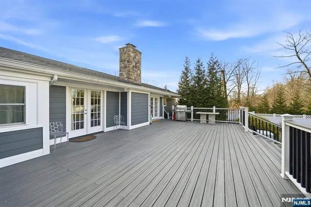 a view of a house with deck wooden floor and fence with a large window