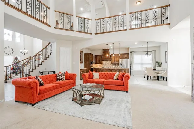 a living room with furniture a fireplace and a chandelier