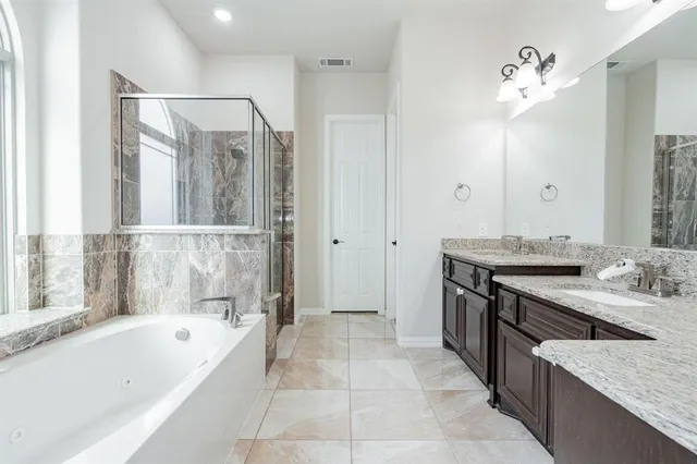 a spacious bathroom with a granite countertop sink a mirror and a shower