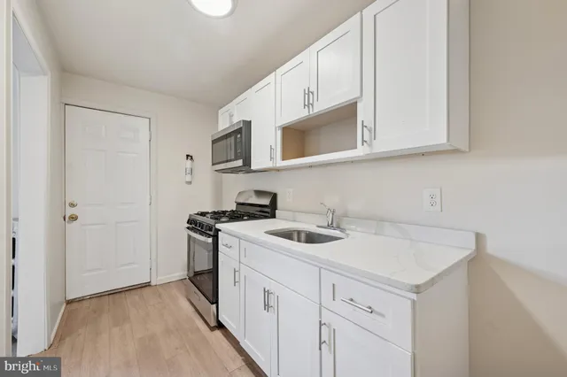 a kitchen with white cabinets and white appliances