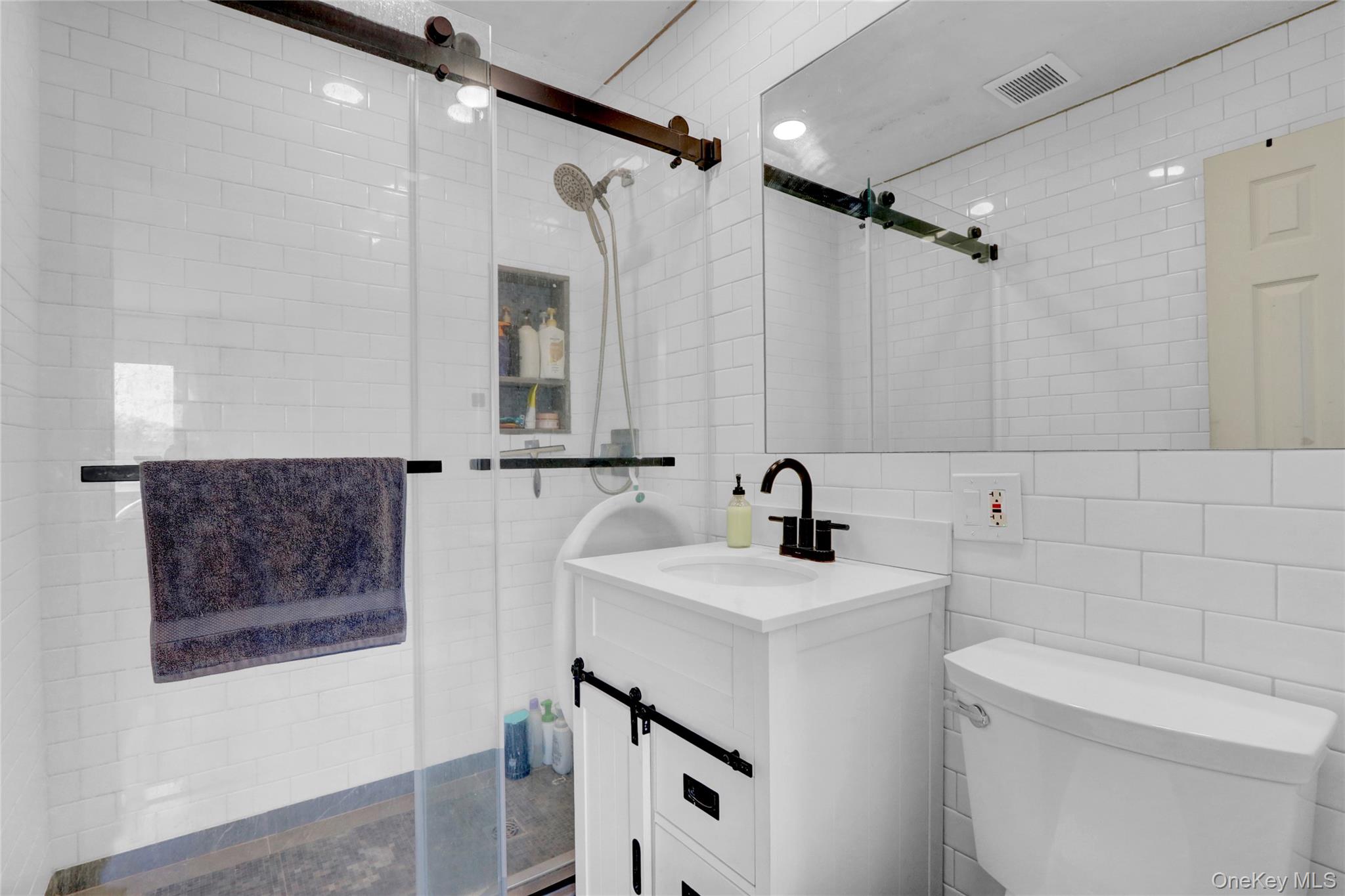 243 Lakeside Trail Ridge, NY 11961 - Photo 14 of 38 a bathroom with a sink a toilet and shower