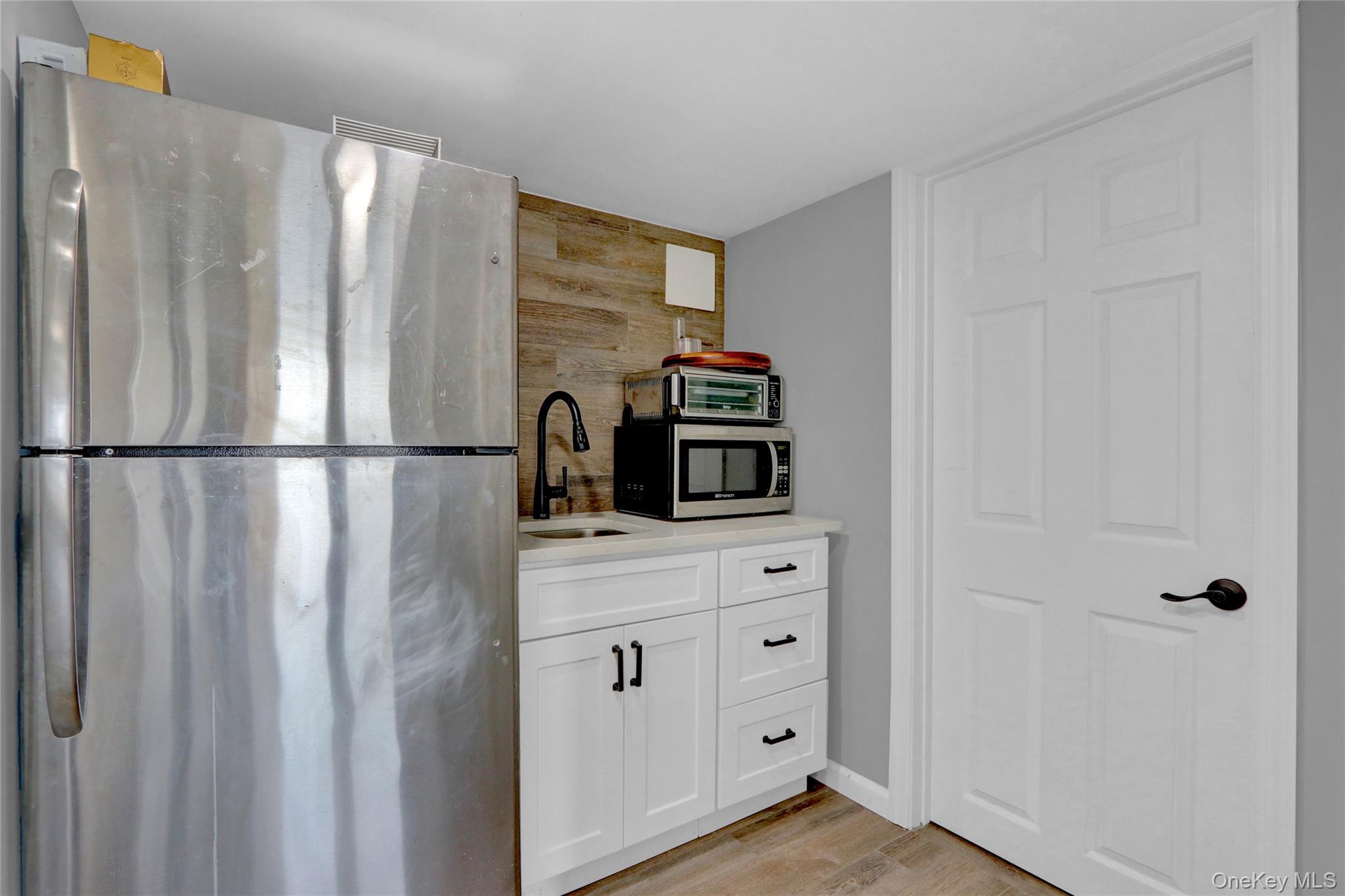 243 Lakeside Trail Ridge, NY 11961 - Photo 19 of 38 a kitchen with a refrigerator and cabinets