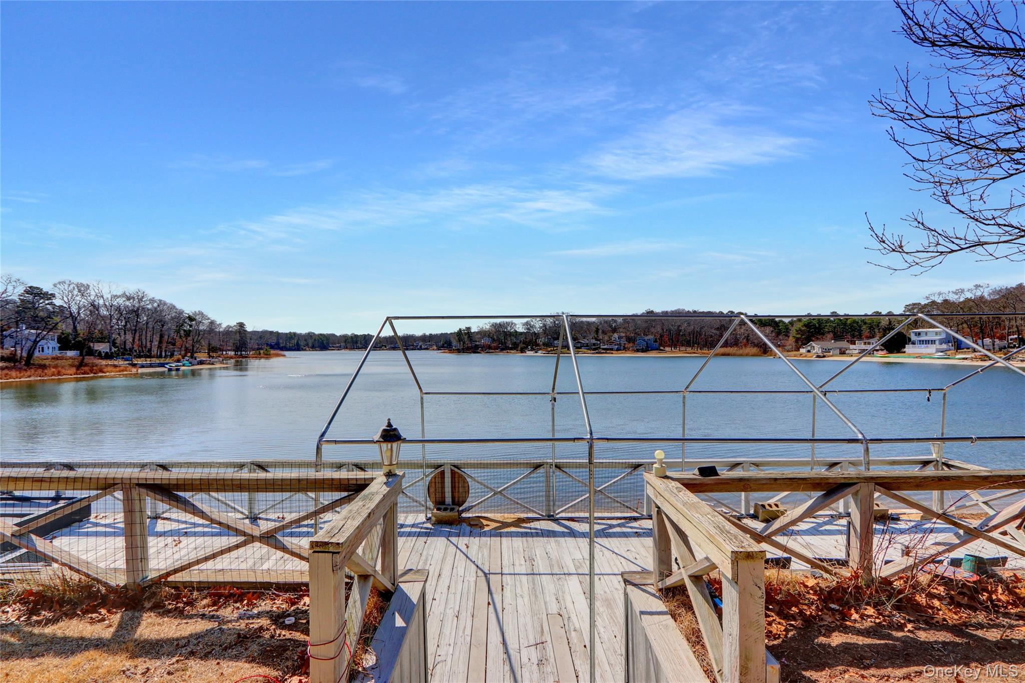 243 Lakeside Trail Ridge, NY 11961 - Photo 30 of 38 a view of a lake from a roof deck with a table and chairs
