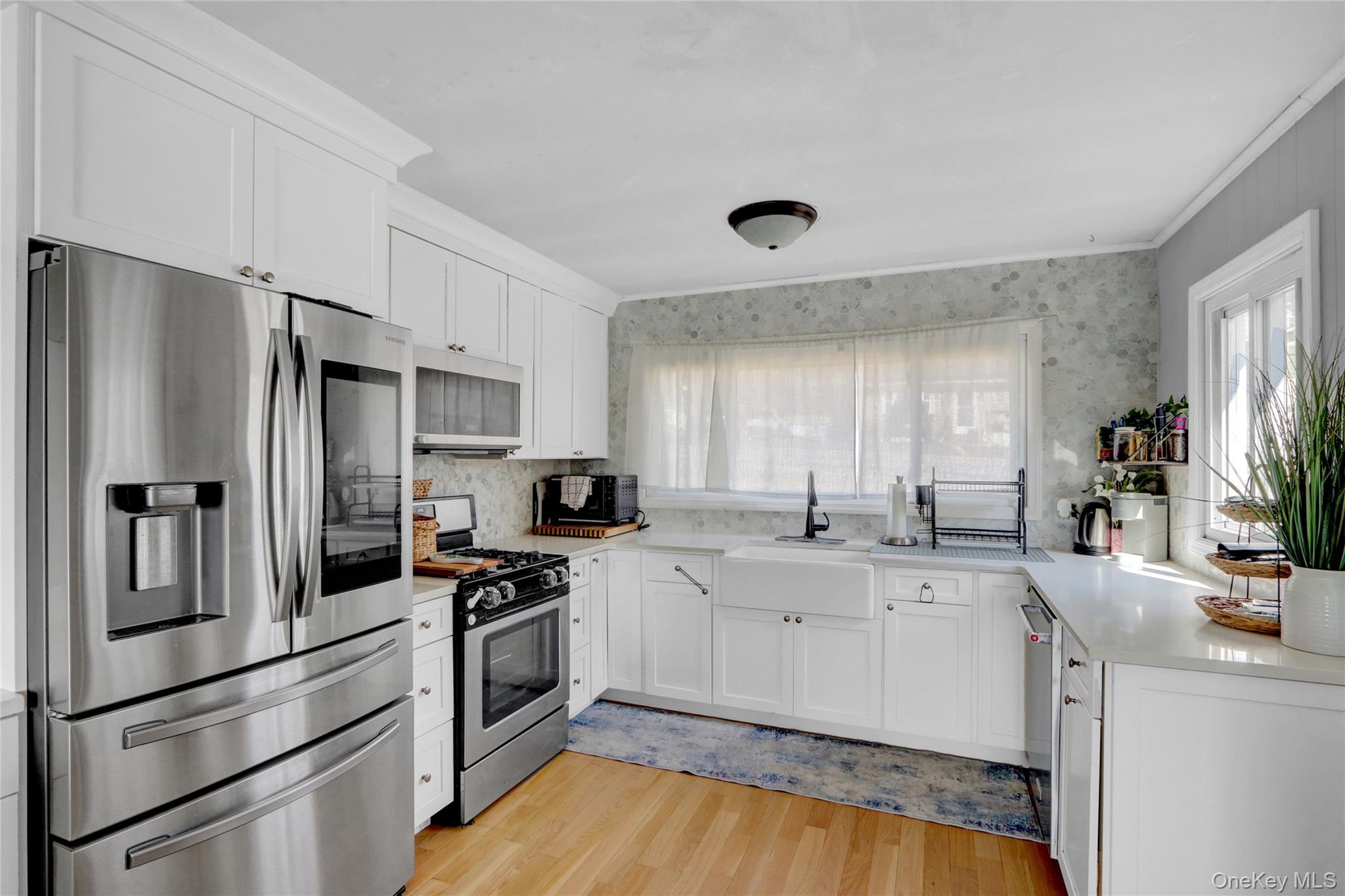 243 Lakeside Trail Ridge, NY 11961 - Photo 10 of 38 a kitchen with white cabinets and stainless steel appliances