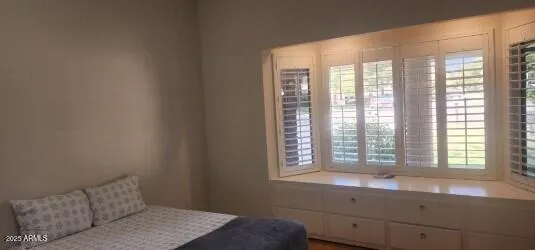 a bedroom with a bed and a window