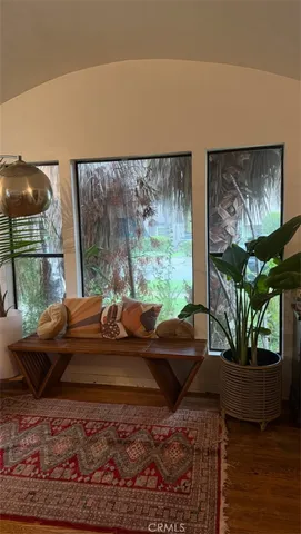a living room with furniture flowerpot and a floor to ceiling window