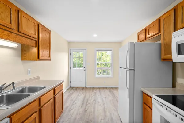 a kitchen that has a sink a stove and wooden floor