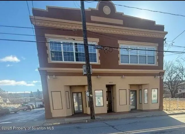 a view of empty room with window and wooden floor