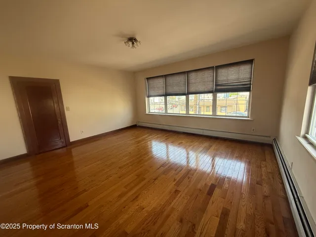 a view of a hallway with wooden floor windows and entryway