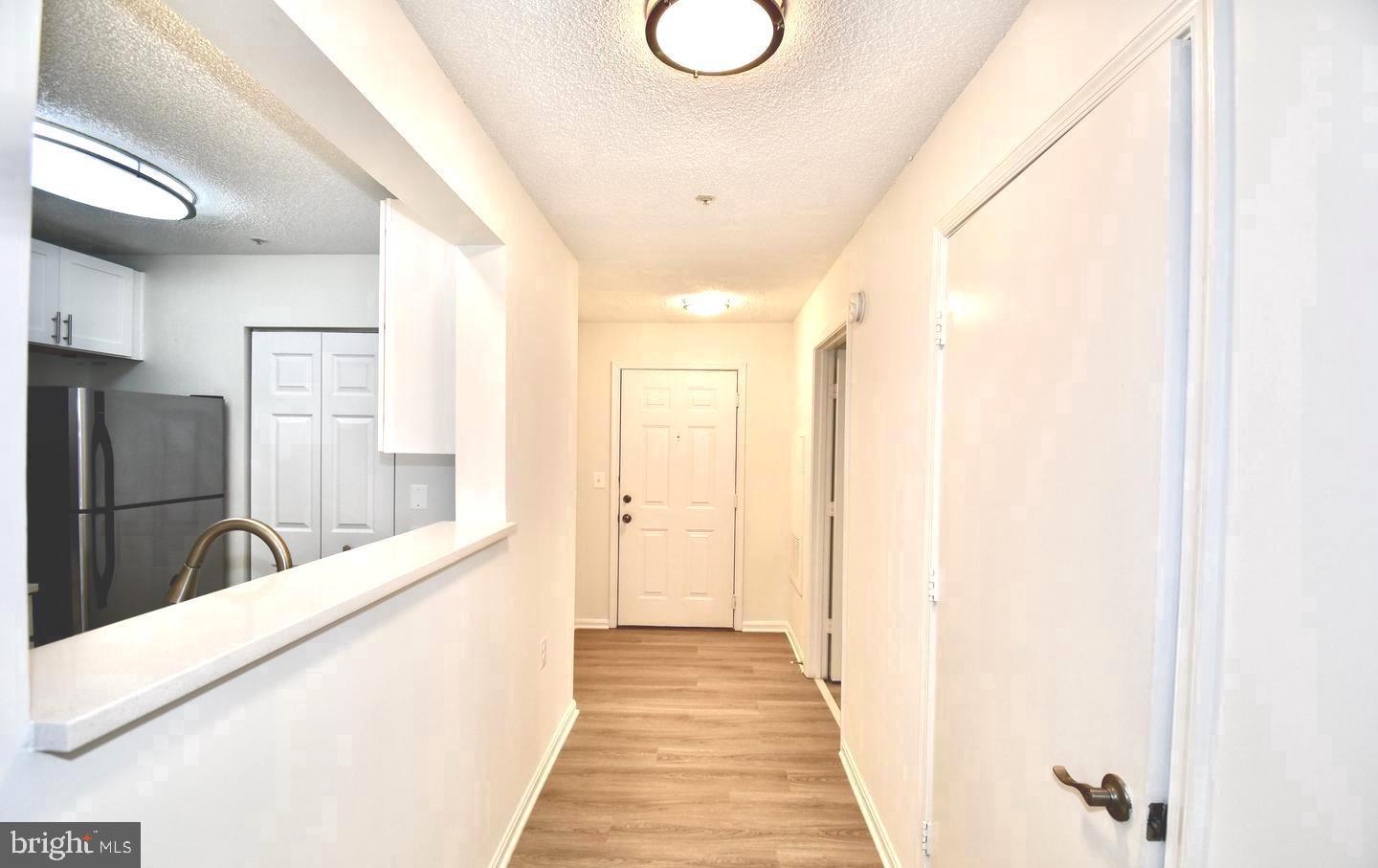 a view of a hallway with wooden floor