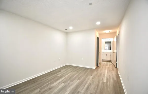 a view of a room with wooden floor and a window