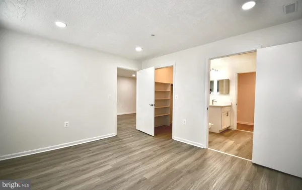 an empty room with wooden floor and bathroom