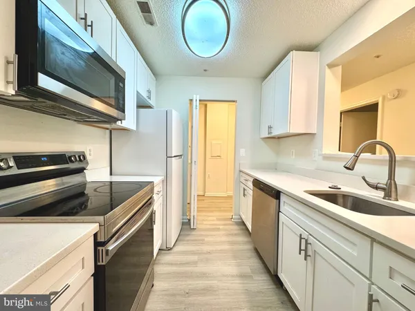 a kitchen with a sink cabinets and stainless steel appliances