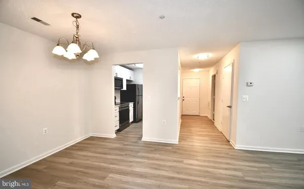 a view of a chandelier in big room with wooden floor