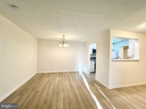 a view of a room with wooden floor staircase and a kitchen