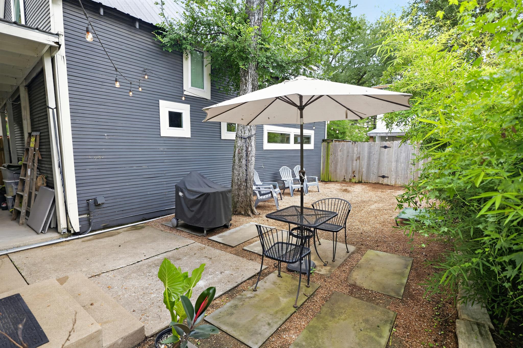 307 East 35th Street, Unit A Austin, TX 78705 - Photo 8 of 40 A secluded outdoor area offers a quaint seating arrangement beneath a broad umbrella.