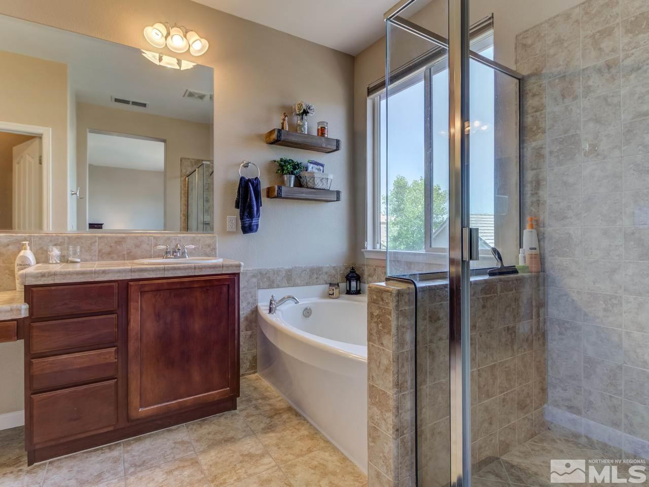 460 Miesque Court Reno, NV 89521 - Photo 18 of 25 a bathroom with a tub a double vanity sink a window and a mirror