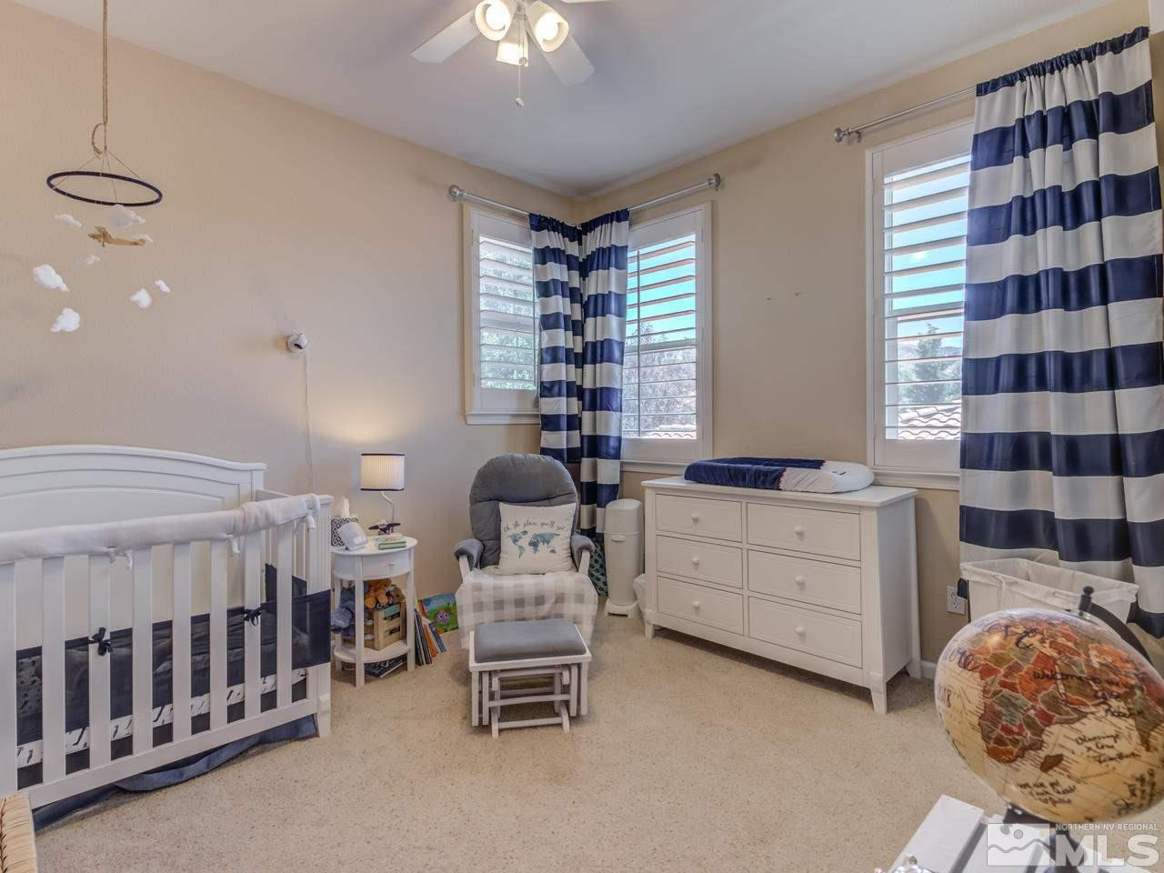 460 Miesque Court Reno, NV 89521 - Photo 20 of 25 a room with a baby crib furniture a chandelier and a window