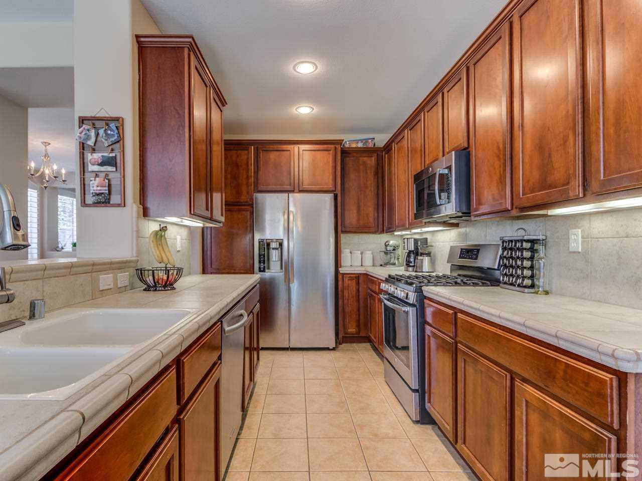 460 Miesque Court Reno, NV 89521 - Photo 10 of 25 a kitchen with stainless steel appliances granite countertop a sink stove and refrigerator