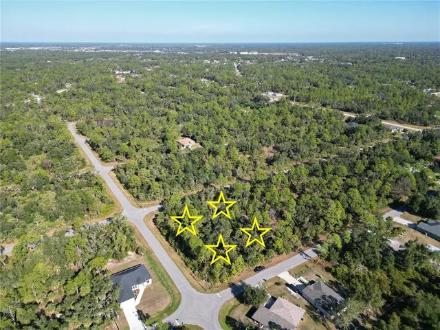 an aerial view of residential houses with outdoor space and trees