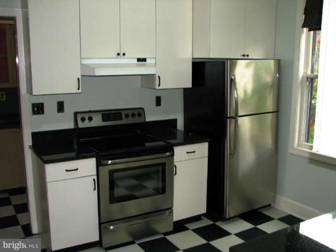 4815 Keswick Road Baltimore, MD 21210 - Photo 13 of 30 a kitchen with a refrigerator and white cabinets