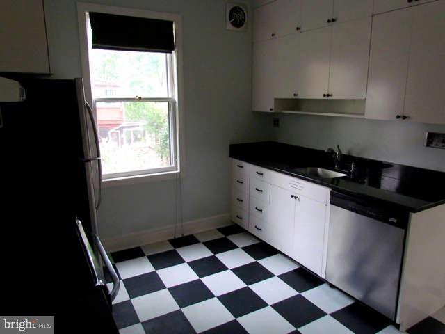 4815 Keswick Road Baltimore, MD 21210 - Photo 14 of 30 a kitchen with granite countertop white cabinets and black appliances