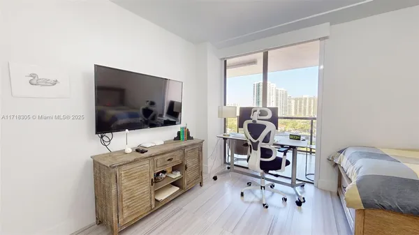 a bedroom with a bed and a flat screen tv