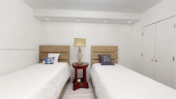 a bedroom with two beds and a night stand