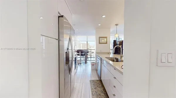 a kitchen with stainless steel appliances granite countertop a stove top oven a sink a dining table and chairs with wooden floor