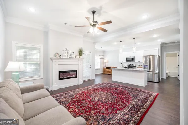 a kitchen with stainless steel appliances granite countertop wooden cabinets a sink a stove a refrigerator and a granite counter tops with wooden floors