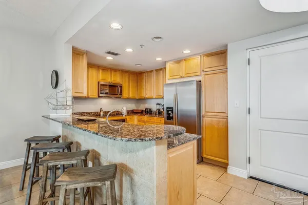 a kitchen with stainless steel appliances granite countertop a stove refrigerator sink and cabinets