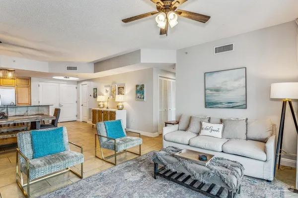 a living room with furniture and a view of kitchen