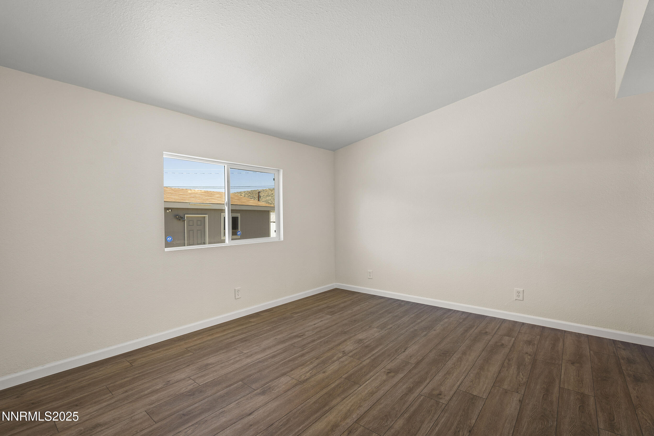 17855 Blackbird Drive Reno, NV 89508 - Photo 12 of 26 a view of an empty room with wooden floor and a window