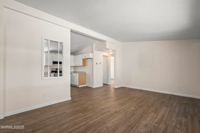 a view of empty room with wooden floor