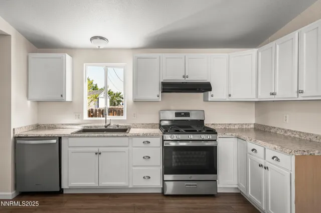 a kitchen with stainless steel appliances granite countertop a stove a sink and a microwave