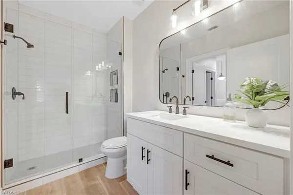 a bathroom with a granite countertop sink a toilet and a shower